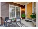 Inviting front porch featuring dark brown siding, a patterned rug, and comfortable chairs at 12451 Turquoise Terrace Pl, Castle Pines, CO 80108