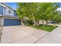View of the home with large trees, a green lawn, and a spacious driveway at 6110 Raleigh Cir, Castle Rock, CO 80104