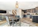 Open-concept living space featuring hardwood floors, a dining table, stainless steel appliances, and stylish decor at 6110 Raleigh Cir, Castle Rock, CO 80104