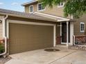 Attached garage and front entrance of a charming home with brick accents and a well-kept exterior at 12599 Elm St, Thornton, CO 80241