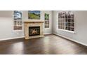 Bright living room with a stone fireplace, hardwood floors, and large windows offering plenty of natural light at 12599 Elm St, Thornton, CO 80241