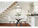 Cozy dining area under stairs, featuring a glass table and comfortable seating at 1978 Newland Ct, Lakewood, CO 80214