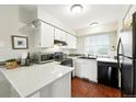 Bright kitchen boasts white cabinets, modern appliances, and hardwood flooring at 1978 Newland Ct, Lakewood, CO 80214