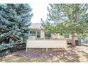 Backyard features mature trees, a concrete patio, and a wood fence at 8423 S Miller Ct, Littleton, CO 80127