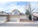 Townhome featuring a two-car garage, stone accents, and low-maintenance landscaping at 8423 S Miller Ct, Littleton, CO 80127