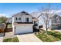 Attractive exterior of home with green lawn, a spacious driveway, and a white garage door at 5189 S Malta Way, Centennial, CO 80015