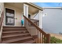 A charming front porch with steps leading up to the entrance and a comfortable seating area at 5189 S Malta Way, Centennial, CO 80015