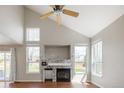 Bright living room with vaulted ceilings, a fireplace with stone accents, and ample natural light from large windows at 5324 S Malta Way, Centennial, CO 80015