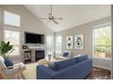 Cozy living room features a fireplace, vaulted ceiling, and abundant natural light from the large windows at 5324 S Malta Way, Centennial, CO 80015