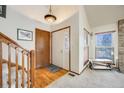 Inviting foyer with hardwood floors, a staircase, and a bright window at 10436 W 84Th Pl, Arvada, CO 80005