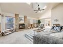 Spacious living room features a brick fireplace and vaulted ceilings with natural light at 10436 W 84Th Pl, Arvada, CO 80005