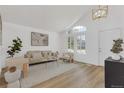 Bright living room with vaulted ceilings, a large window, and modern decor at 1260 Ascot Ave, Highlands Ranch, CO 80126