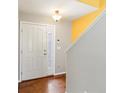 Bright foyer featuring hardwood floors, a white front door, and a staircase at 4816 S Elk Way, Aurora, CO 80016