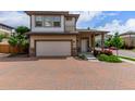 Charming two-story home boasts a brick driveway, attached two-car garage, and inviting front porch at 10580 Waco St, Commerce City, CO 80022