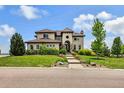 Elegant two-story home showcasing lush landscaping, a manicured lawn, and a welcoming walkway to the front entrance at 7724 Kryptonite Ln, Castle Rock, CO 80108