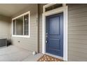Charming front entrance with a blue door, decorative mat, and well-maintained exterior at 9071 E Phillips Dr, Centennial, CO 80112