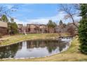 Beautiful community pond with waterfall, manicured landscaping, and surrounding residential buildings at 9071 E Phillips Dr, Centennial, CO 80112