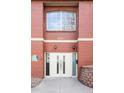 Close-up of the apartment building entrance with a modern double door and brick facade at 1415 N Washington St # 303, Denver, CO 80203