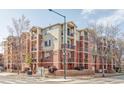 Exterior view of a multi-story brick apartment building with balconies and well-maintained landscaping at 1415 N Washington St # 303, Denver, CO 80203