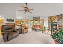 Inviting living room with cozy seating, a stone fireplace, large windows, and a ceiling fan at 29825 Kennedy Gulch Rd, Conifer, CO 80433