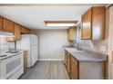 Updated kitchen with white appliances, wood cabinets, and new vinyl flooring at 1791 Quail St, Lakewood, CO 80215