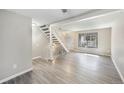Open-concept living room boasts new flooring, staircase and large window at 1791 Quail St, Lakewood, CO 80215
