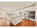 Spacious kitchen with stainless steel appliances, a large island, and hardwood floors at 7895 Julsburg Cir, Littleton, CO 80125