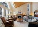 Cozy living room with a fireplace, large windows, a wooden ceiling, and comfortable seating at 17420 Caribou Dr, Monument, CO 80132