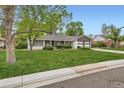 Well-maintained front yard with mature trees framing the classic home at 502 Nile St, Aurora, CO 80010