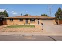 Charming brick home featuring a well-manicured lawn and a two-car garage at 5915 W 5Th Ave, Lakewood, CO 80226