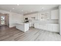 Spacious, all-white kitchen featuring a large island, plentiful cabinet space, and modern finishes at 6646 N Nepal St, Aurora, CO 80019