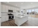 Modern kitchen with stainless steel appliances, white cabinetry, island, and ample counter space at 6646 N Nepal St, Aurora, CO 80019