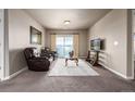 Comfortable living room with plush seating, modern decor, and sliding glass door leading to balcony at 9258 Rockhurst St # 303, Highlands Ranch, CO 80129