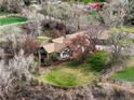 Expansive single-story home on a large, beautifully landscaped lot with mature trees and a private setting at 11489 W Bear Creek Dr, Lakewood, CO 80227