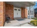 Inviting entryway with double doors, brick accents, and a concrete porch for curb appeal at 18263 E Berry Dr, Centennial, CO 80015