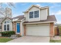 Charming two-story home featuring a bright blue door, brick accents, and a two-car garage at 116 S Lindsey St, Castle Rock, CO 80104