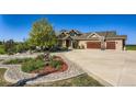 Charming home showcasing manicured landscaping, a large driveway, and a basketball hoop over the garage at 960 Promontory Cir, Elizabeth, CO 80107