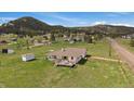 Single-story home on a large lot with an attached garage and a rustic wooden fence, nestled in a green, mountainous area at 11173 Emerald Ln, Conifer, CO 80433