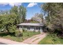Inviting single-story home with a well-maintained lawn, mature trees, and a gravel driveway at 270 31St St, Boulder, CO 80305