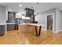 Open kitchen features gray and white cabinets, modern appliances and a large island with seating at 2724 Federal Blvd # 2, Denver, CO 80211