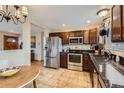 Modern kitchen with stainless steel appliances, granite countertops, and a tile floor at 9068 Dudley St, Broomfield, CO 80021