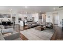 Spacious open-concept living area with hardwood floors, a comfortable sofa, and ample seating at 8815 S Tibet Ct, Aurora, CO 80016