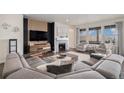 Cozy living room with a fireplace, modern furnishings, a large sectional sofa, and ample natural light at 8815 S Tibet Ct, Aurora, CO 80016