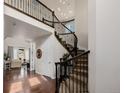 Elegant foyer with a curved staircase, hardwood floors, and a view into the living room at 15205 W Iliff Ave, Lakewood, CO 80228