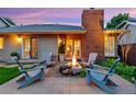 Cozy backyard patio with stone fireplace, Adirondack chairs and exterior doors at 13 Pinyon Pine Rd, Littleton, CO 80127