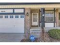 Inviting front porch with a storm door, bay window, brick accents, and a secure ADT security system at 18646 E Garden Pl, Aurora, CO 80015