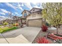Beautiful home featuring a manicured lawn, a welcoming porch, and a convenient two-car garage at 7763 S Elk St, Aurora, CO 80016
