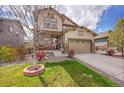 Attractive two-story home with a lush green lawn, a covered porch, and an attached two-car garage at 7763 S Elk St, Aurora, CO 80016