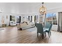Bright living room with hardwood floors, large windows, stylish furniture, and decorative chandelier at 2468 Candleglow St, Castle Rock, CO 80109