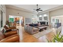 Open-concept living room with hardwood floors, high ceilings, and modern furnishings; adjacent to kitchen at 7126 E 162Nd Ct, Brighton, CO 80602